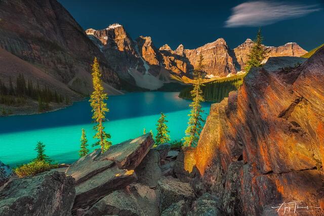 An extraordinary and one-of-a-kind photograph showcasing the stunning Moraine Lake in Banff . Captures the lake's breath taking colour in the ethereal light.