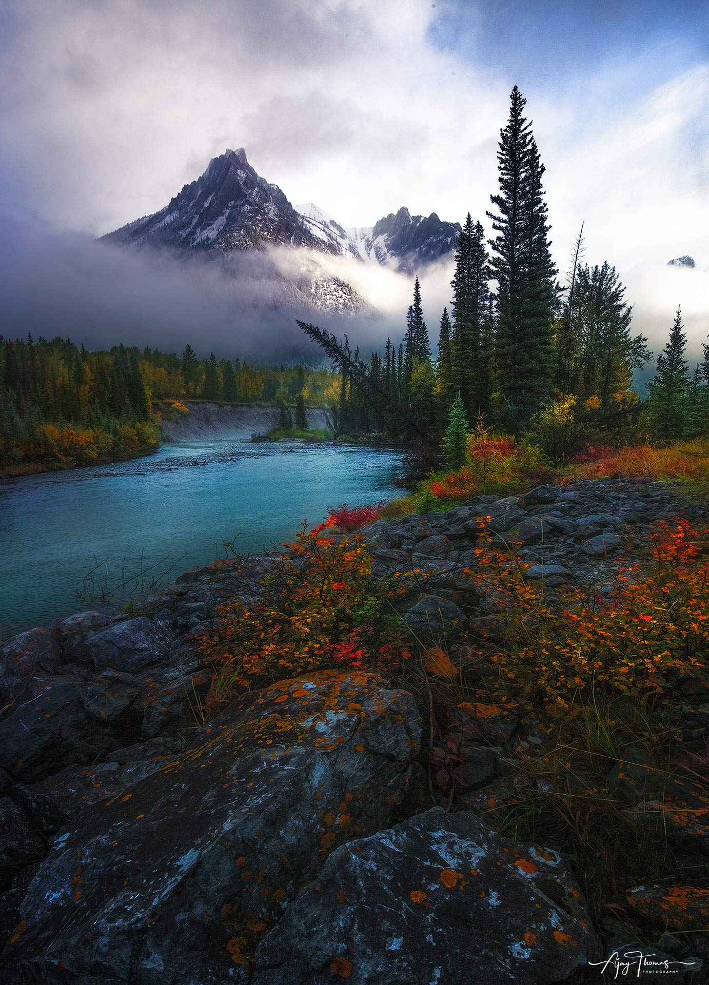 Morning in mountains with fog, light, snow, and fall colours 