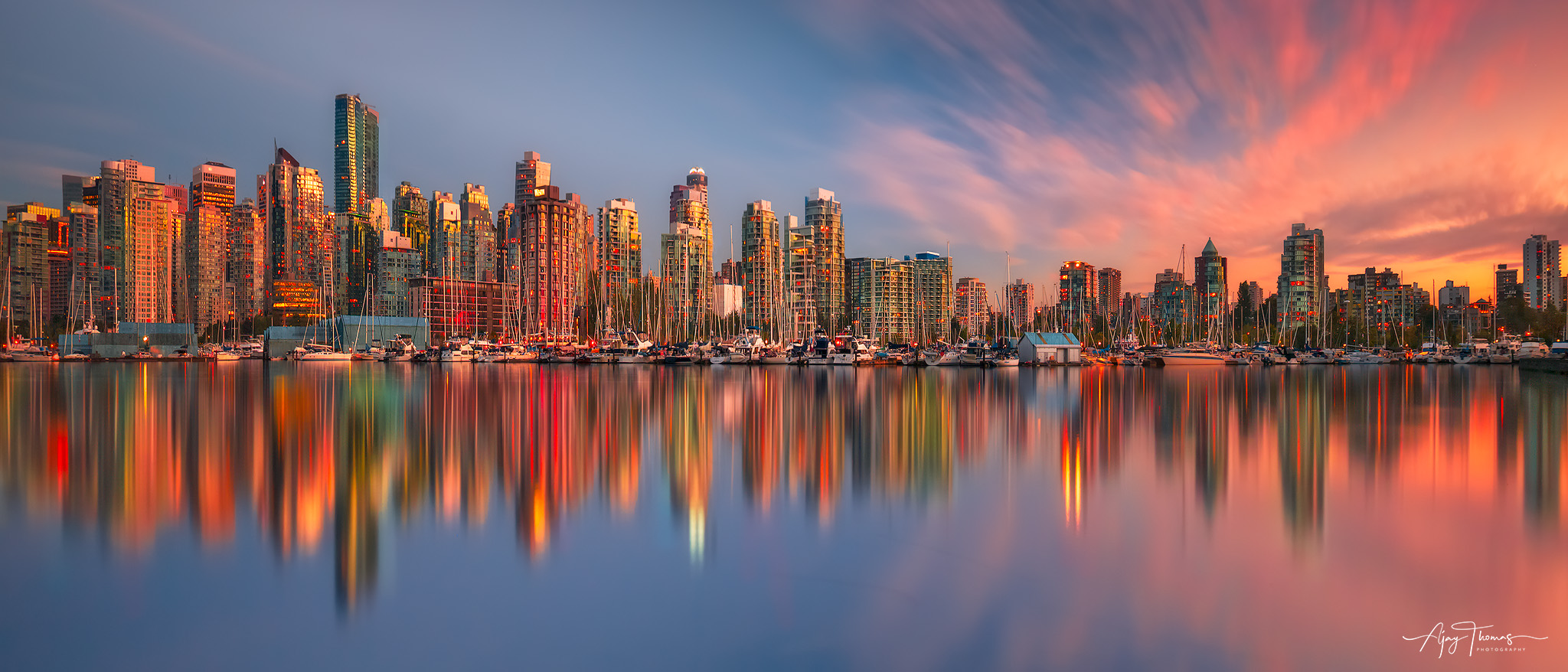 A panoramic view of Vancouver city skyline reflections during sunset.  A long exposure shot from Stanley park,vancouver